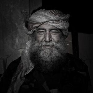 Il s'agit d'une photographie d'art. Disponible à la vente sur le site de Paragone Concept. Elle représente le portrait d'un homme. Celui ci étant un syrien, agent immobilier de son état, qui fut obligé de devenir soldat dans son pays en guerre.